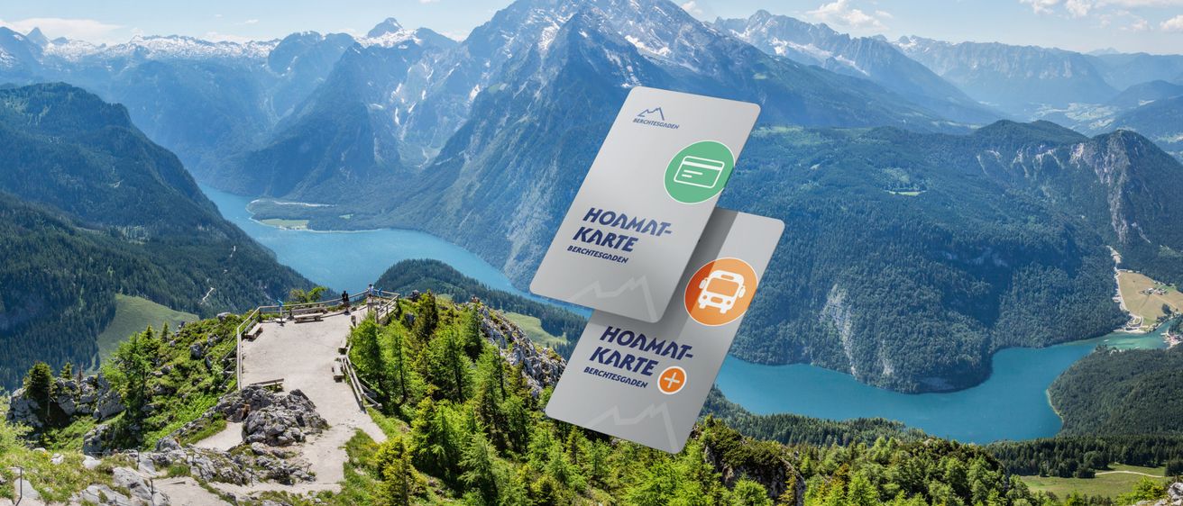 Zwei Heimatkarten schweben über einer wunderschönen Berglandschaft. Ein See und Berge umgeben die Szene.