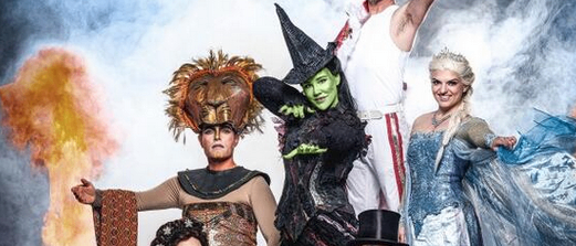 Eine Gruppe von Schauspielern in Fantasiekostümen posiert für ein Foto. Die Frau in einem weißen Kleid hält einen Fächer.