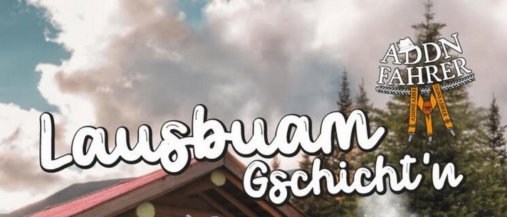 Ein Mann in Hut und Hosenträger steht lächelnd vor einem Briefkasten, mit einem Blockhaus und Herbstbäumen im Hintergrund.