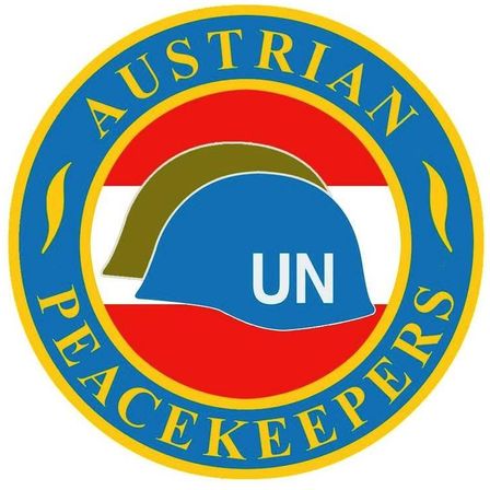 Das Logo der österreichischen Friedenskräfte zeigt einen blauen Helm mit weißen UN-Buchstaben. Die Worte 'Austrian Peacekeepers' sind in Blau auf rotem und weißem Hintergrund geschrieben.