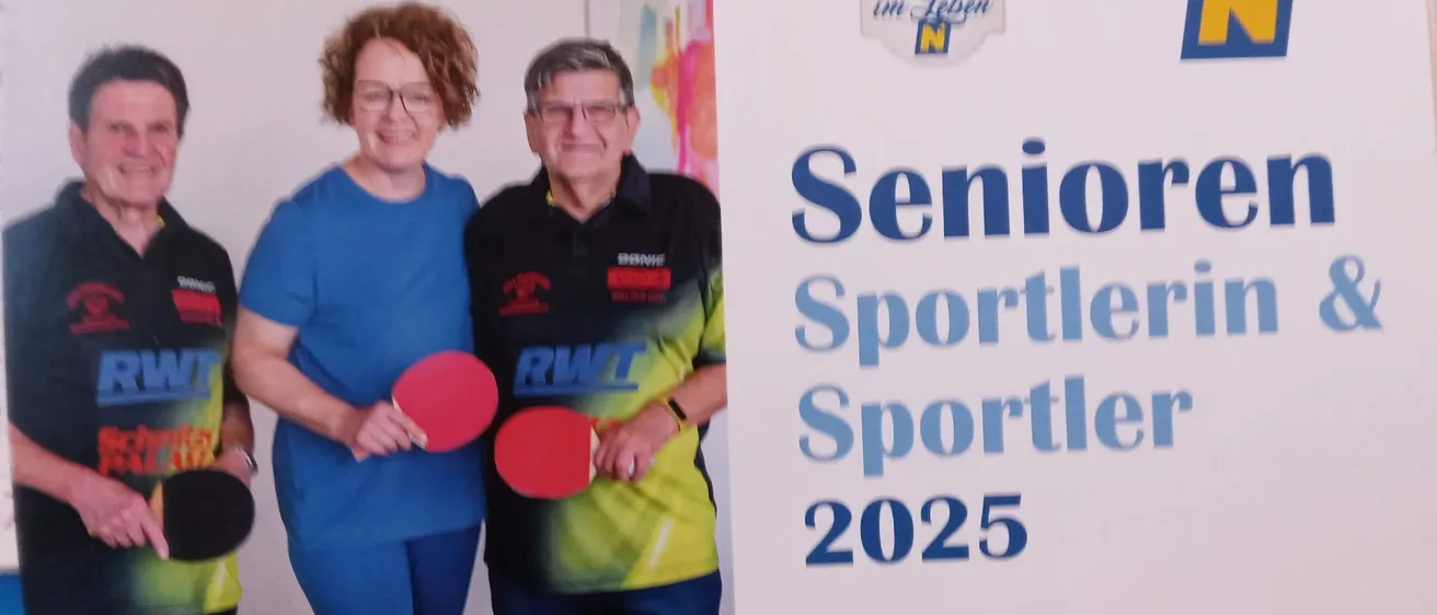 Drei Personen stehen vor einem Tischtennistisch, lächeln und halten Schläger. Ein Banner im Hintergrund zeigt 'Senior Sportler Sportlerin 2025' und 'EINLADU'.