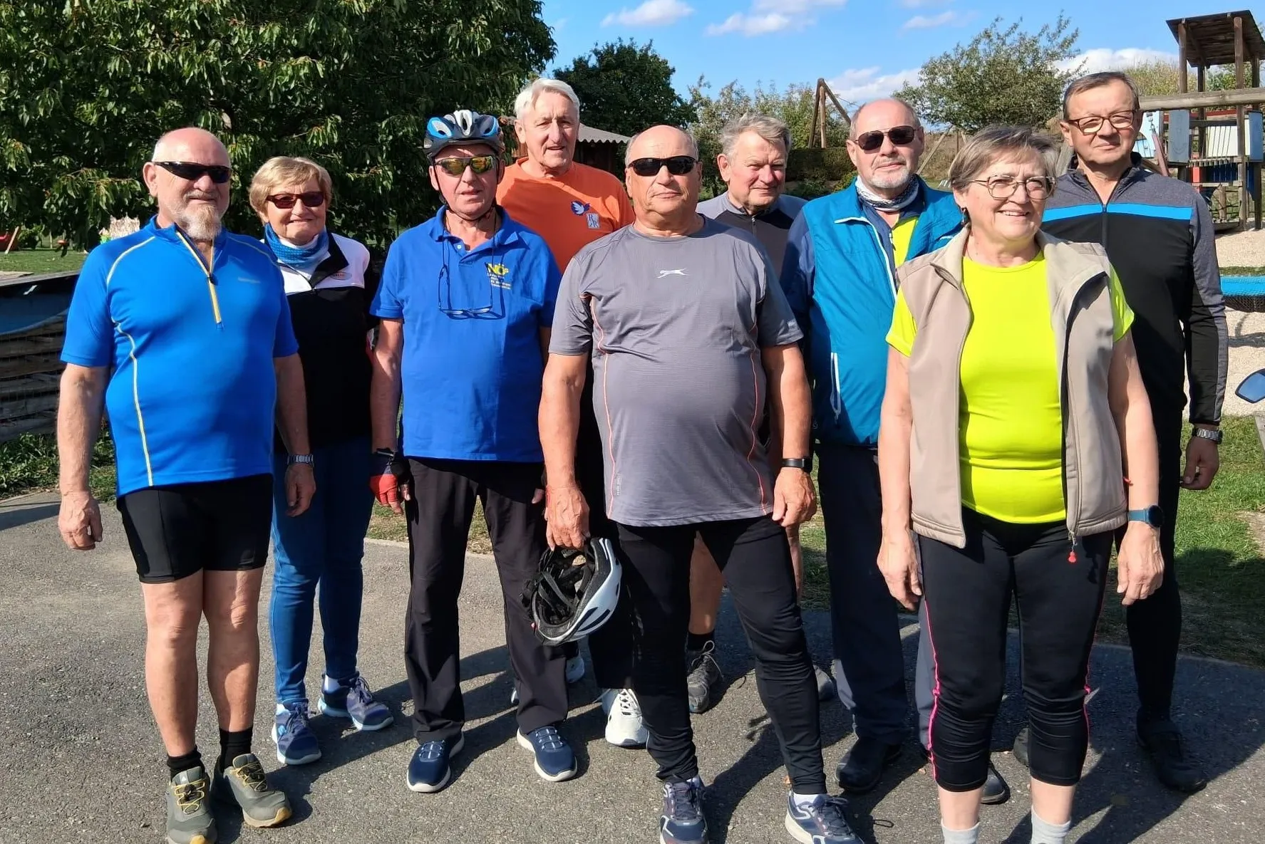 Eine Gruppe von Menschen in Outdoor-Kleidung steht zusammen in einem Park.