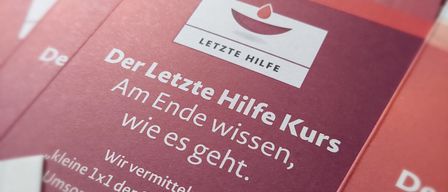 Eine Broschüre mit dem Titel 'Der Letzte Hilfe Kurs' ist prominent ausgestellt. Sie konzentriert sich auf die Bereitstellung von Anleitung für die Sterbebegleitung.
