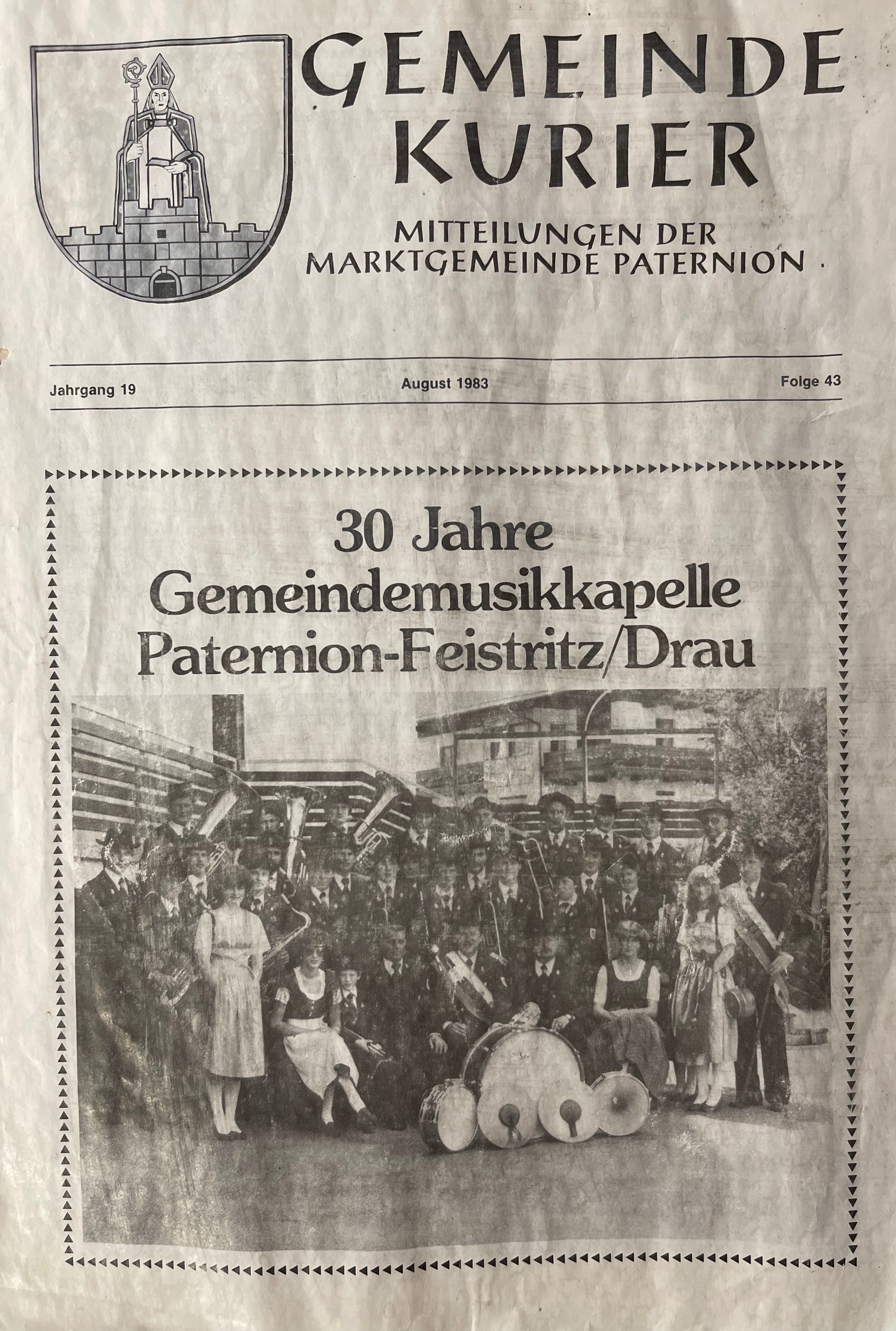 Ein Zeitungsausschnitt aus August 1983 zeigt eine Blaskapelle, die 30 Jahre feiert. Die Gruppe ist in traditioneller Kleidung, mit Instrumenten wie Trompeten und Trommeln.