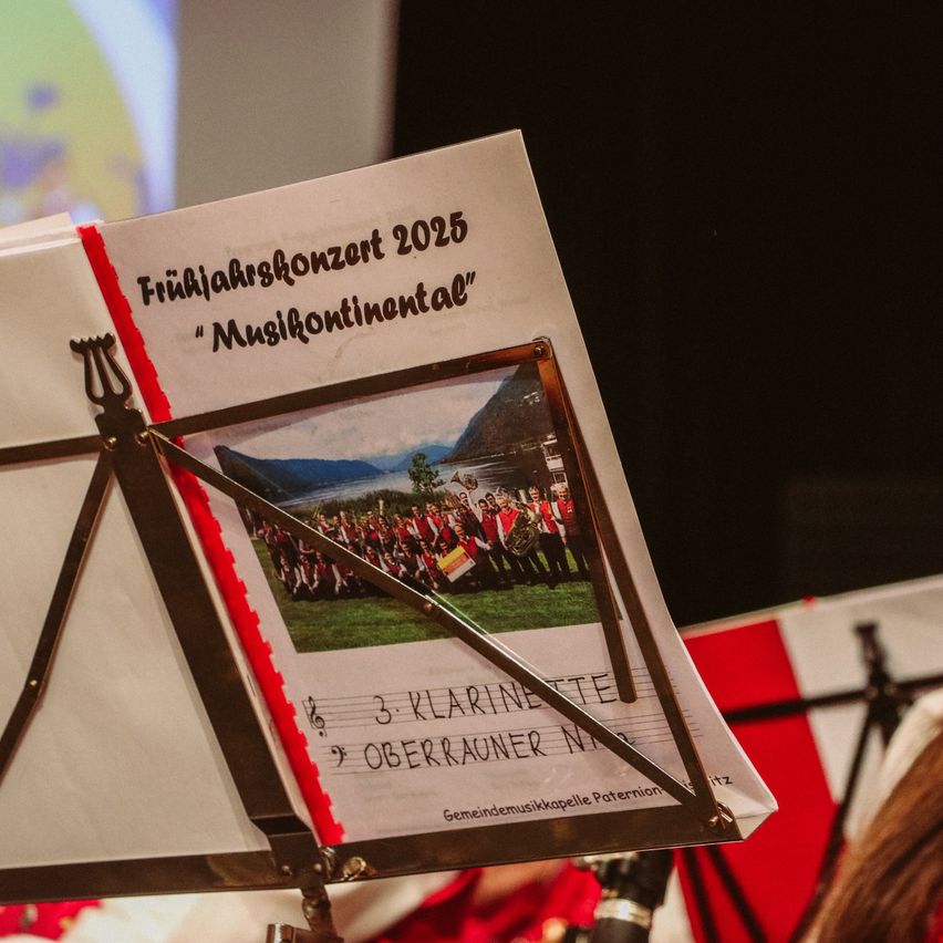Notenblatt mit dem Titel 'Friijahrskonzert 2025' und einem Foto einer Band auf dem Cover.
