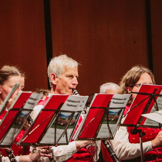 Eine Gruppe von Musikern, darunter ein Mann, der Klarinette spielt, tritt bei einem Konzert auf.
