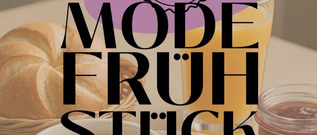 Ein Tisch mit einer Tasse Kaffee, einem Ei, einem Glas Orangensaft und einem Glas Marmelade. Brot in einem Korb ist ebenfalls sichtbar. Die Worte 'Mode Fruh Stuck' sind in Fettdruck.