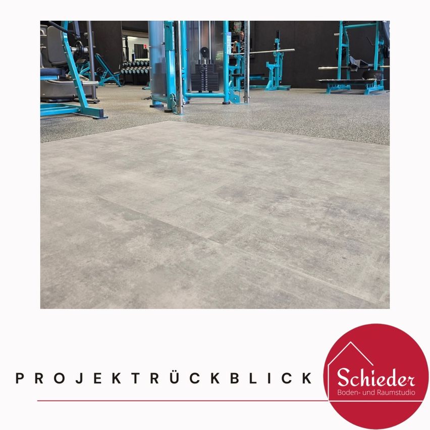 Das Innere eines Fitnessstudios mit grauen Bodenbelägen und blauen Trainingsgeräten, die vor einem weißen Hintergrund dargestellt sind.