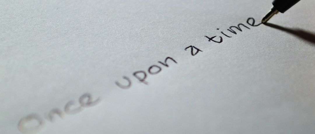Ein Nahaufnahme einer handgeschriebenen Notiz auf weißem Papier. Der Text lautet 'Es war einmal'.