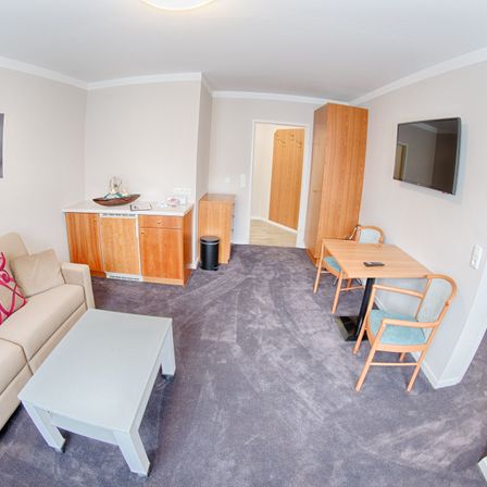 Bild enthält, Corner, Indoors, Living Room, Table, Computer Hardware, Monitor, Screen, Interior Design, TV, Couch