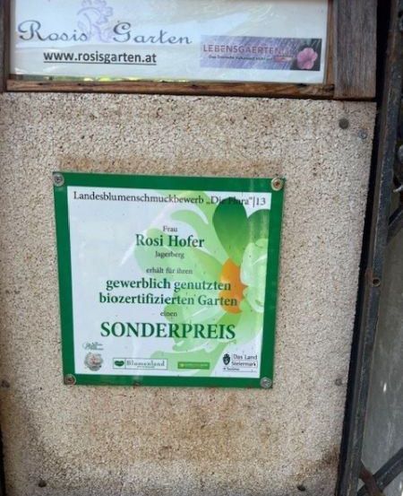 Ein Gartenschild von Rosi Hofer in Jagerberg. Es steht 'Sonderpreis' und 'Bio-zertifizierter Garten'. Die Webseite ist www.rosisgarten.at.