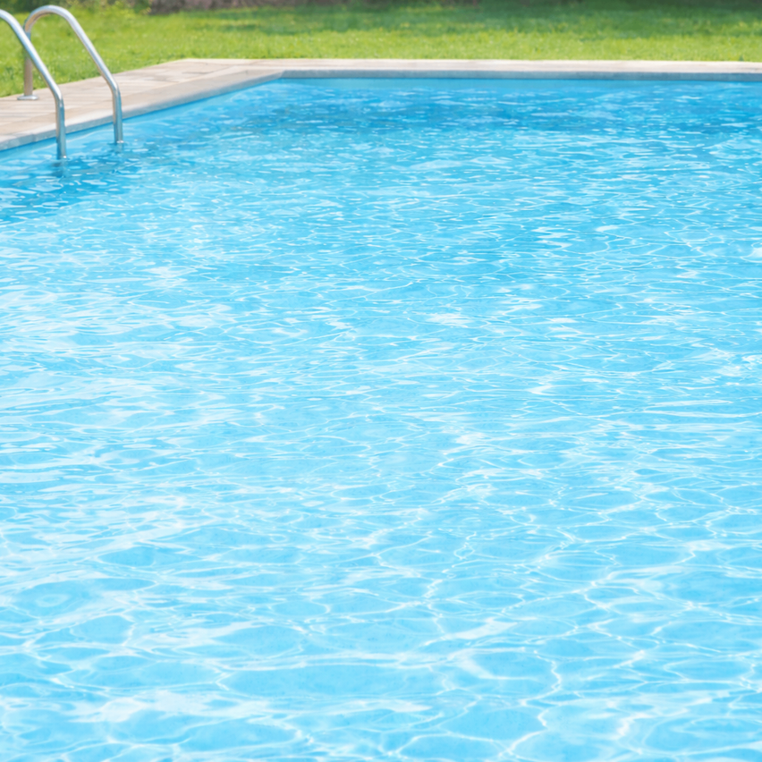 Ein leerer rechteckiger Pool mit einer Metallhandlauf auf der linken Seite. Das Wasser ist klar und sauber.