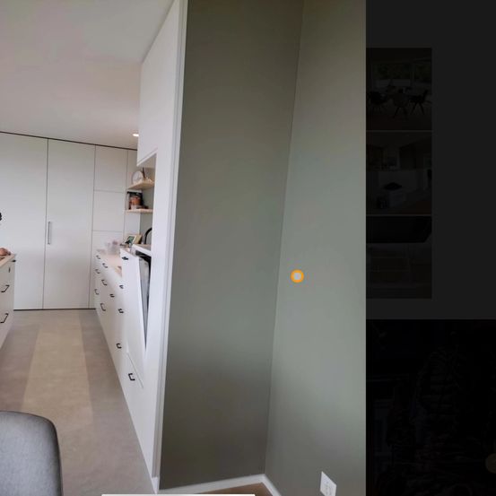 Ein Bild einer Ecke in einem Raum, das weiße Schränke mit mehreren Schubladen, eine graue Wand und einen gelben Kreis in der Mitte zeigt.