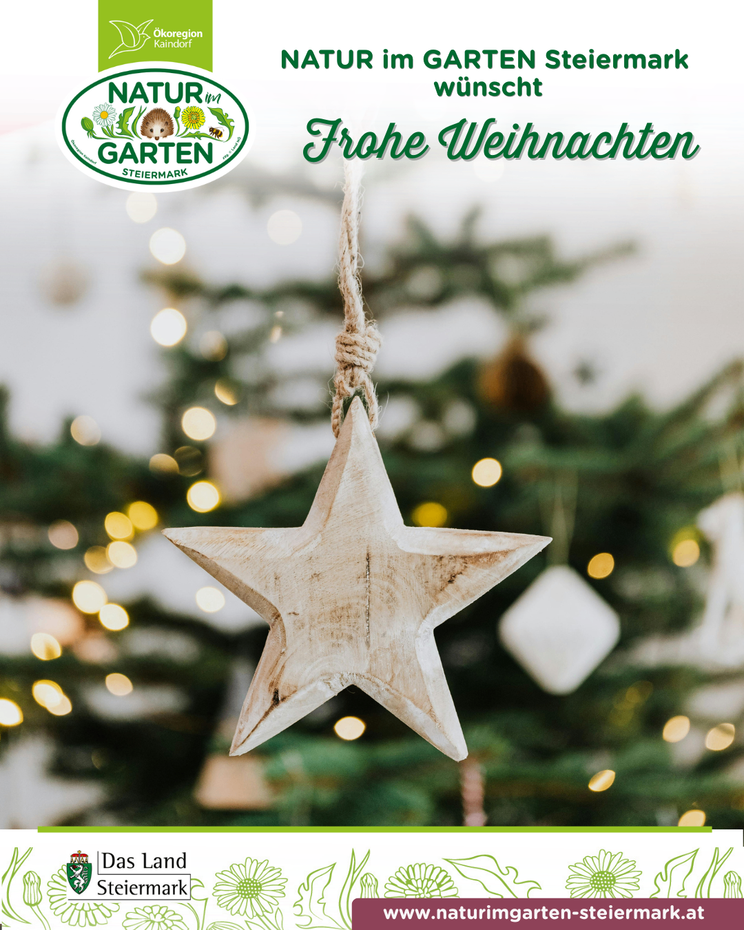 Ein hölzerne Sterndekoration hängt an einem Weihnachtsbaum mit der Aufschrift 'Frohe Weihnachten' darüber. Der Baum ist mit Lichtern und Ornamenten geschmückt.