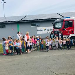 Bild enthält, People, Person, Transportation, Truck, Vehicle, Fire Truck, Footwear, Shoe, Jeans, Fire Station