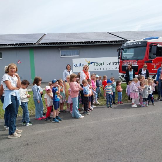 Bild enthält, People, Person, Clothing, Pants, Jeans, Vehicle, Truck, Fire Truck, Shoe, Fire Station