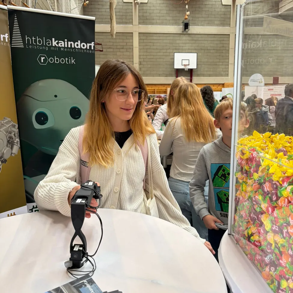 Eine Frau mit einer Brille und einem Rucksack hält eine Kamera und schaut auf eine Display von Süßigkeiten.
