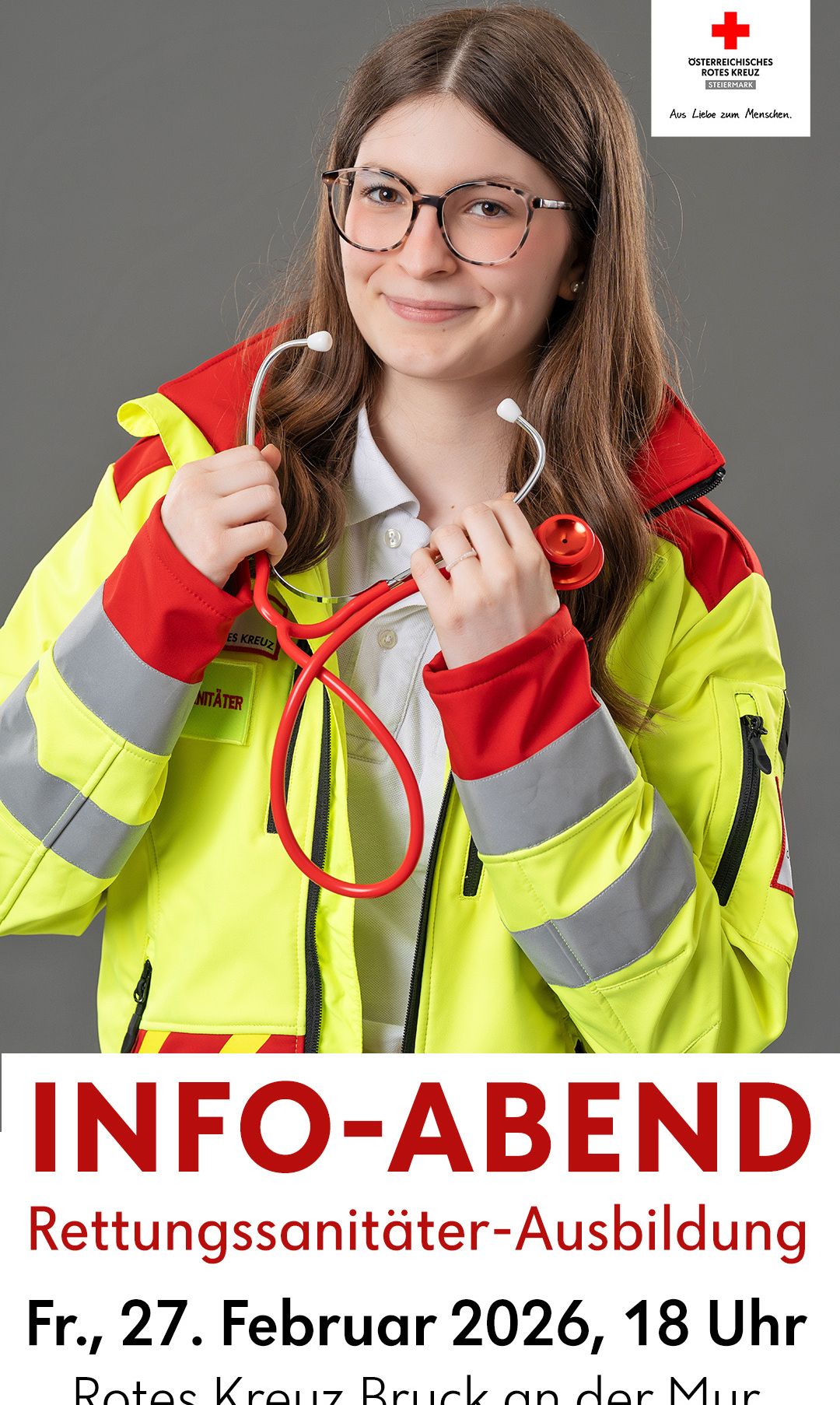 Eine Frau in einer reflektierenden gelben und roten Jacke hält ein Stethoskop und lächelt für ein Foto. Die Jacke hat reflektierende Streifen. Das Bild hat einen Wasserzeichen, der 'INFO-ABEND' lautet.