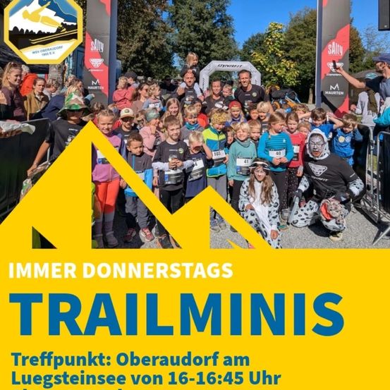 Eine Gruppe von Kindern mit Startnummern steht vor einem gelben Dreieck und Schild. Die Veranstaltung heißt Trailminis. Der Treffpunkt ist Oberaudorf am Luegsteinsee von 16-16:45 Uhr.