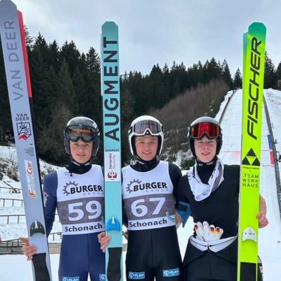Drei Skifahrer stehen im Schnee und halten jeweils ein Paar Skier. Der linke Skifahrer hat einen Burger Group 59 Ski, der mittlere einen Augment Ski und der rechte einen Fischer Ski. Sie tragen alle Helme und Schutzbrillen.