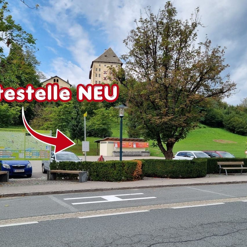 Eine Straßenszene mit einem roten Pfeil, der auf ein Schild zeigt, das 'teststelle NEU' liest. Es sind Autos geparkt, ein Laternenpfahl und ein Baum im Hintergrund.