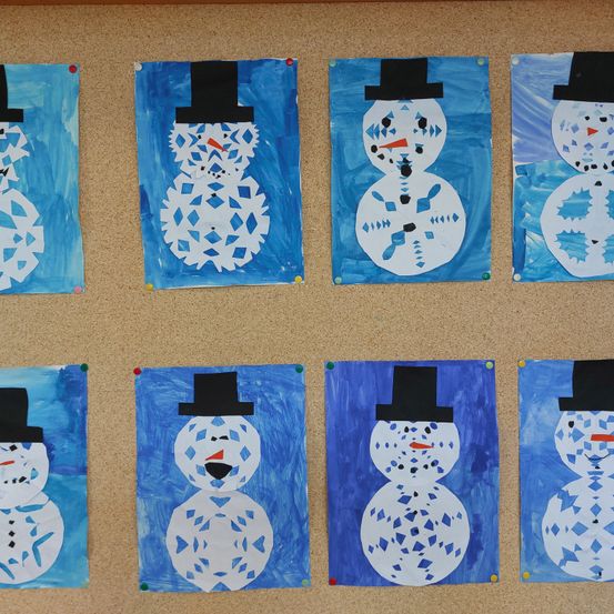 Eine Reihe von neun Kunstwerken mit blauem Hintergrund, die Papierschneemänner mit schwarzen Hüten und roten Nasen zeigen, sind auf einer braunen Oberfläche ausgestellt. Jeder Schneemann ist einzigartig mit Schneeflockenmustern verziert.