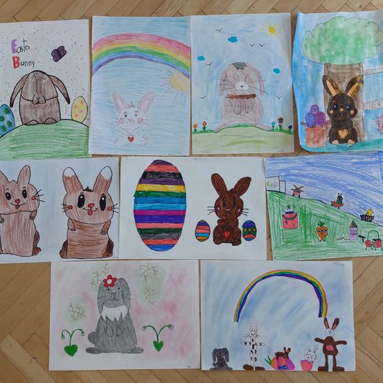 Eine Sammlung von kindlichen Zeichnungen von Osterhasen auf Papier mit verschiedenen Hintergründen, einschließlich Regenbögen, Bäumen und Ostereiern. Die Zeichnungen sind in Stil und Detail unterschiedlich.