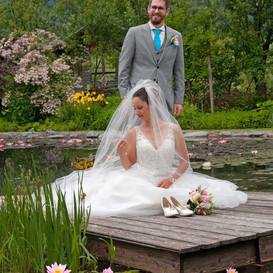 Bild enthält, Dress, Formal Wear, Flower, Flower Arrangement, Flower Bouquet, Gown, Suit, Pond, Wedding Gown, Portrait