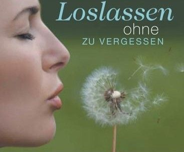Eine Frau, die auf einen Löwenzahn pustet, mit dem Text 'Loslassen ohne zu vergessen' über ihrem Kopf. Sie schaut auf den Löwenzahn, der im Fokus ist. Der Hintergrund ist verschwommen grün.