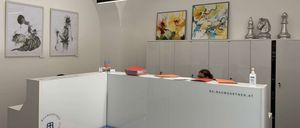 Bild enthält, Furniture, Table, Reception, Painting, Indoors, Desk, Person, Glasses, Face, Clinic