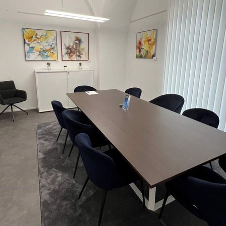 Bild enthält, Indoors, Furniture, Table, Tabletop, Meeting Room, Office, Painting, Chair, Plant, Desk