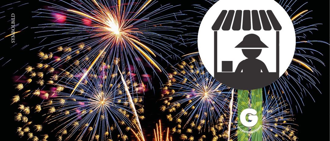 Ein Feuerwerk mit einer großen Explosion in der Mitte. Eine Person in einem Hut ist vor den Feuerwerken silhouettiert.