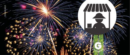 Ein Feuerwerk mit einer großen Explosion in der Mitte. Eine Person in einem Hut ist vor den Feuerwerken silhouettiert.