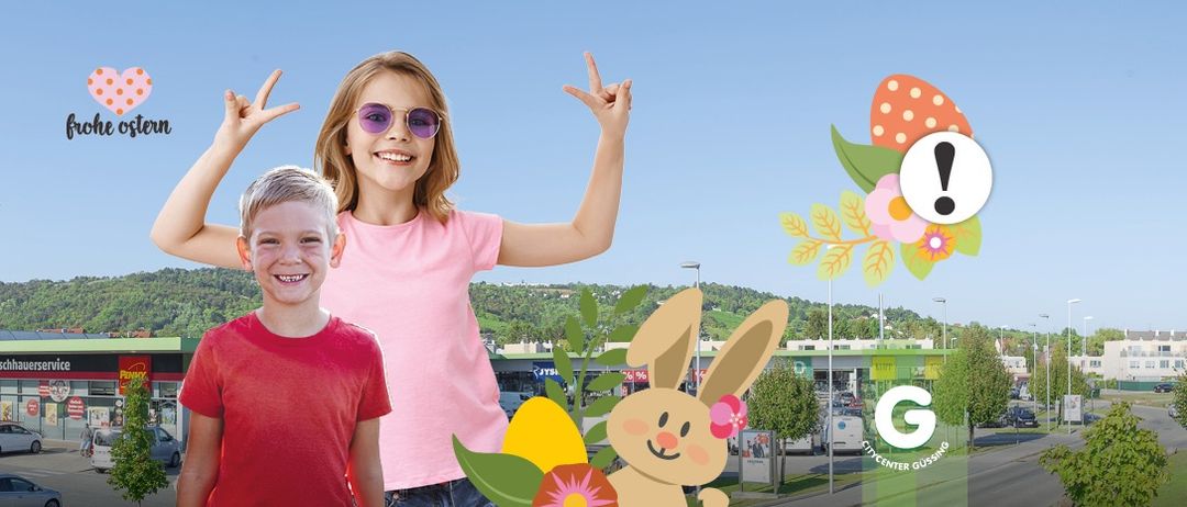 Zwei Kinder stehen in der Nähe eines Einkaufszentrums, eines lächelt und das andere macht eine Friedensgeste. Sie sind von Osterdekorationen umgeben.