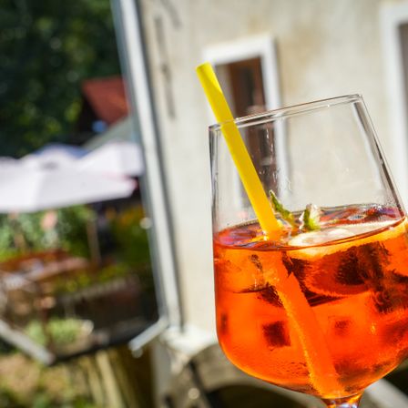 Die Aufnahme zeigt einen leckeren Aperitiv und im Hintergrund die Ottersbachmühle.