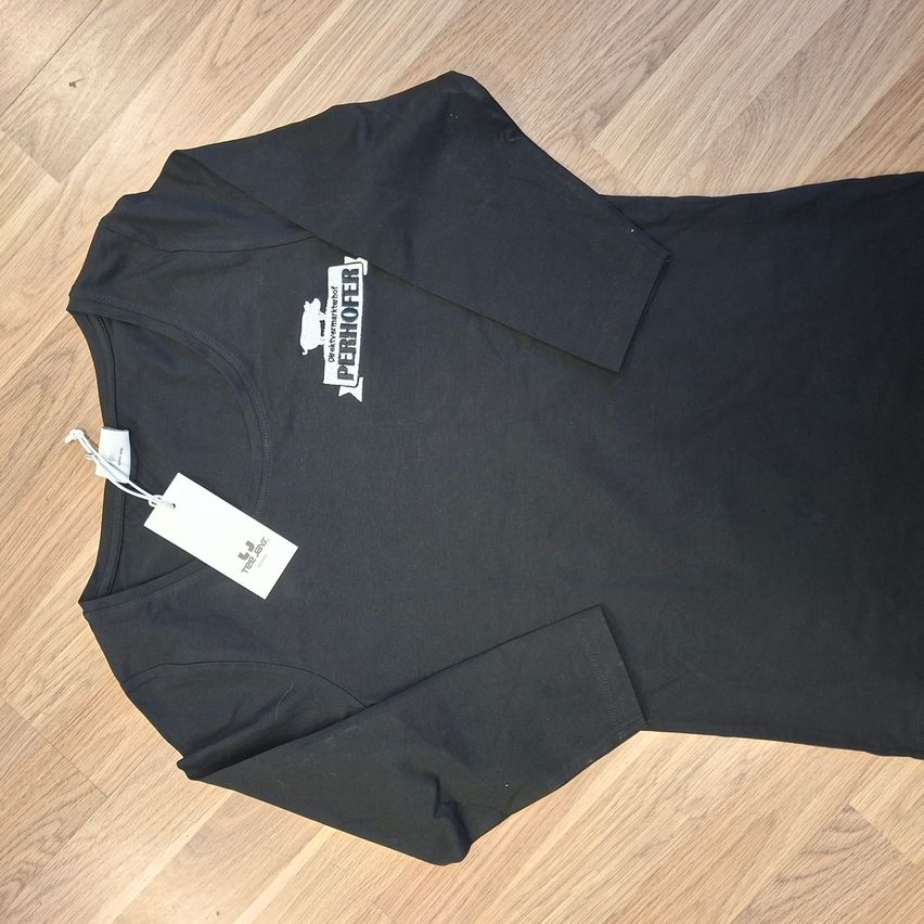 Ein schwarzes Langarmshirt mit dem Wort Pernhofer in Weiß auf der linken Seite. Ein weißer Aufhänger ist am linken Ärmel befestigt.