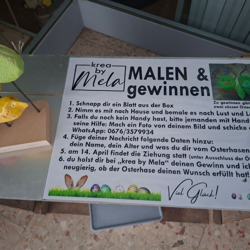 An informational poster on a table encourages participants to take a sheet from a box, and if they lack a handyman, they can ask someone for help. It also provides a WhatsApp number and mentions a drawing on April 14.