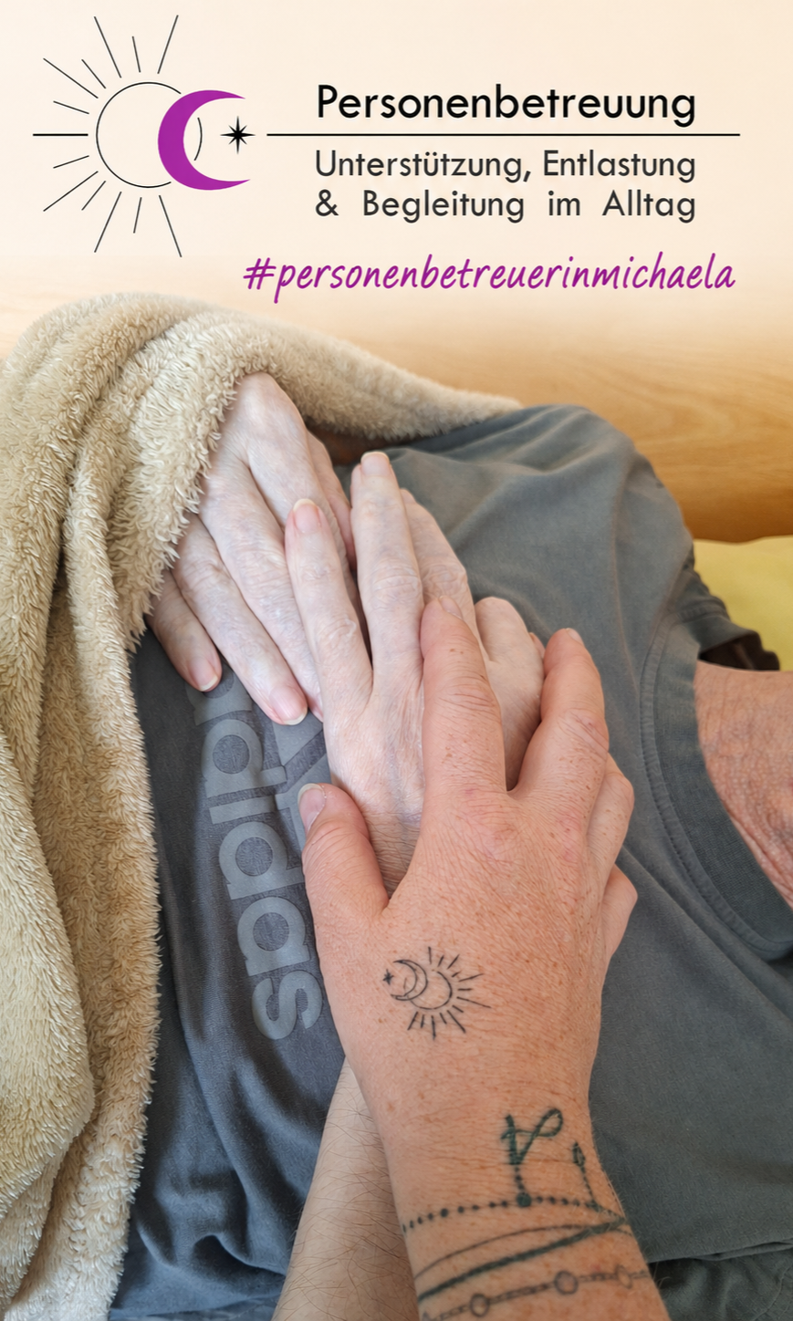 Eine ältere Person liegt mit ihren Händen, die von einer Decke bedeckt sind, auf einem Bett. Ein Tattoo der Sonne ist sichtbar.