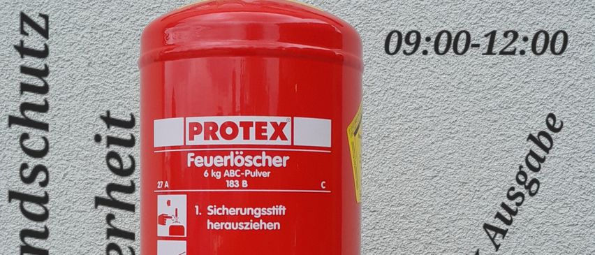 Ein roter Protex-Feuerlöscher an einer Wand mit Anweisungen auf Deutsch und Terminen für Brandschutzinspektionen.