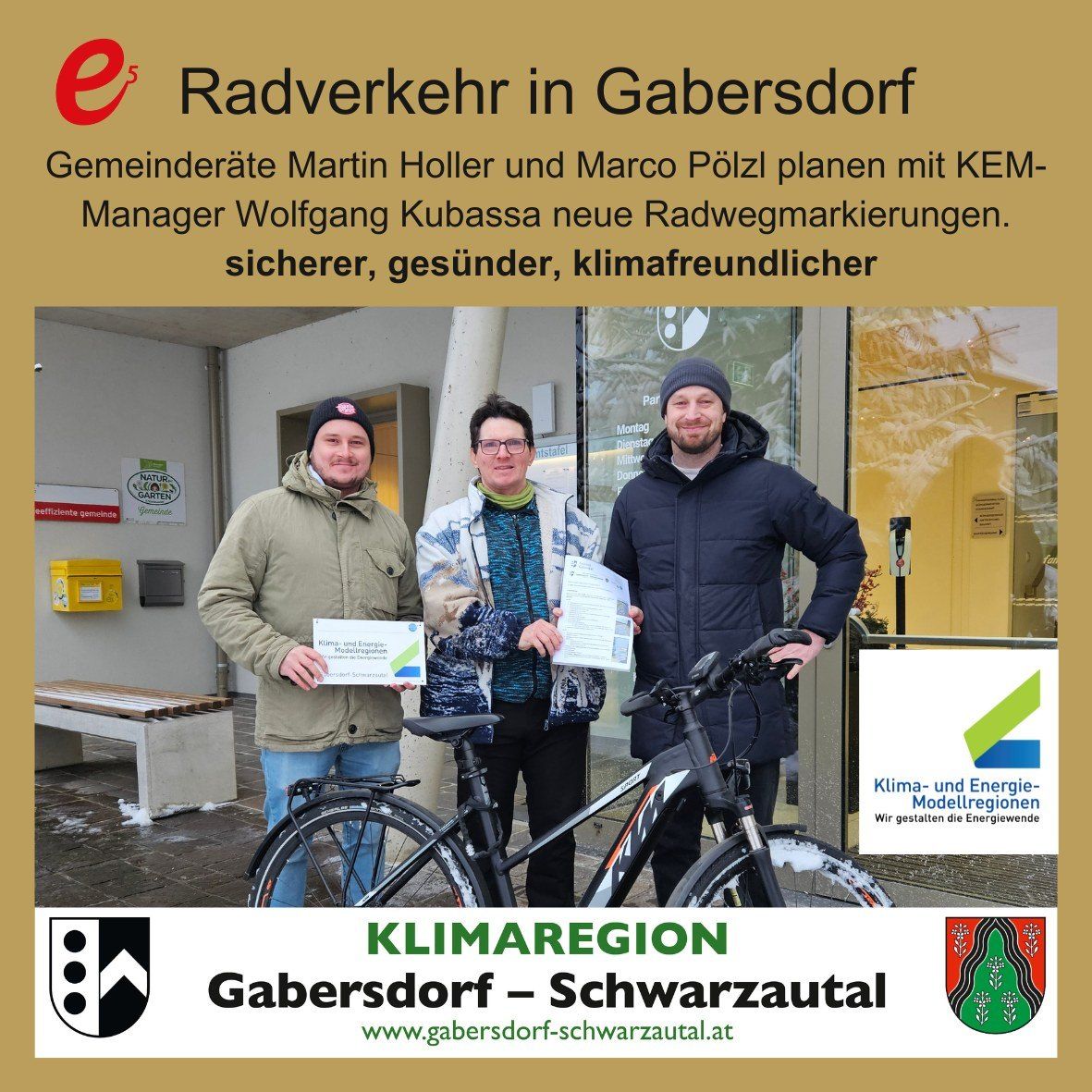Drei Männer stehen vor einem Gebäude mit einem Fahrrad und halten Urkunden in den Händen. Der Text auf dem Bild lautet 'Radverkehr in Gabersdorf' und 'Klima-und Energie-Modellregionen'. Der Mann links lächelt, während die anderen beiden ernst aussehen.