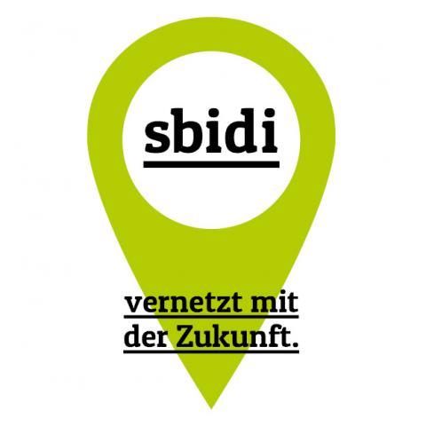 Ein grüner Kartenpin mit dem Text 'sbidi' und einem Slogan, der 'verbunden mit der Zukunft' lautet. Der Pin hat einen weißen Kreis in der Mitte mit dem Text 'sbidi' in schwarz.