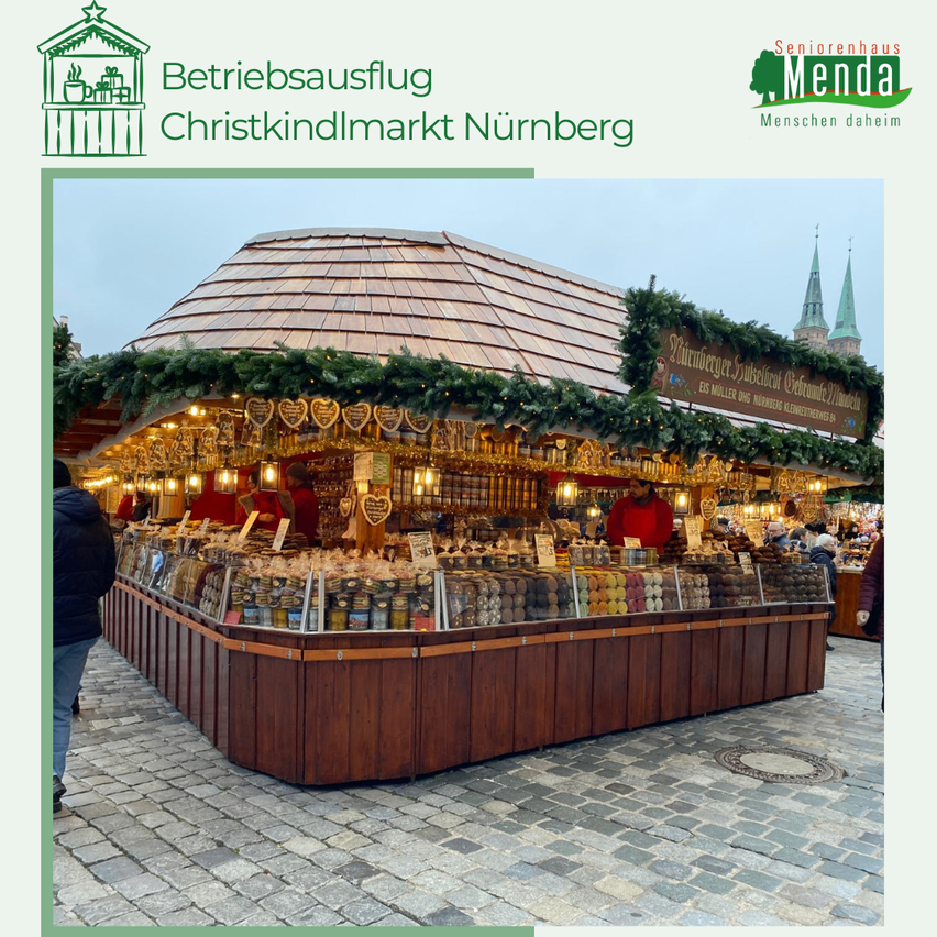 Ein hölzerner Stand mit einem mit Girlanden und Lichtern bedeckten Dach, der verschiedene Süßigkeiten und Snacks verkauft. Der Stand befindet sich auf einer Kopfsteinpflasterstraße.