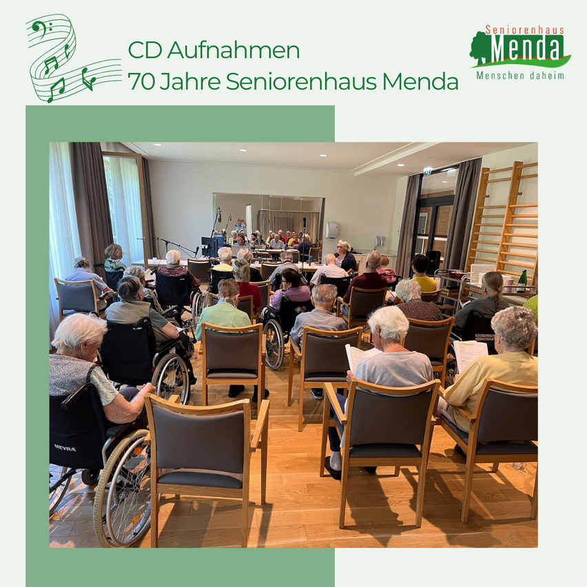 Eine Gruppe älterer Menschen sitzt bei einer CD-Aufnahme-Veranstaltung zur Feier der 70 Jahre von Seniorenheim Menda in Stühlen, mit einer Bühne und musikalischen Noten im Hintergrund.