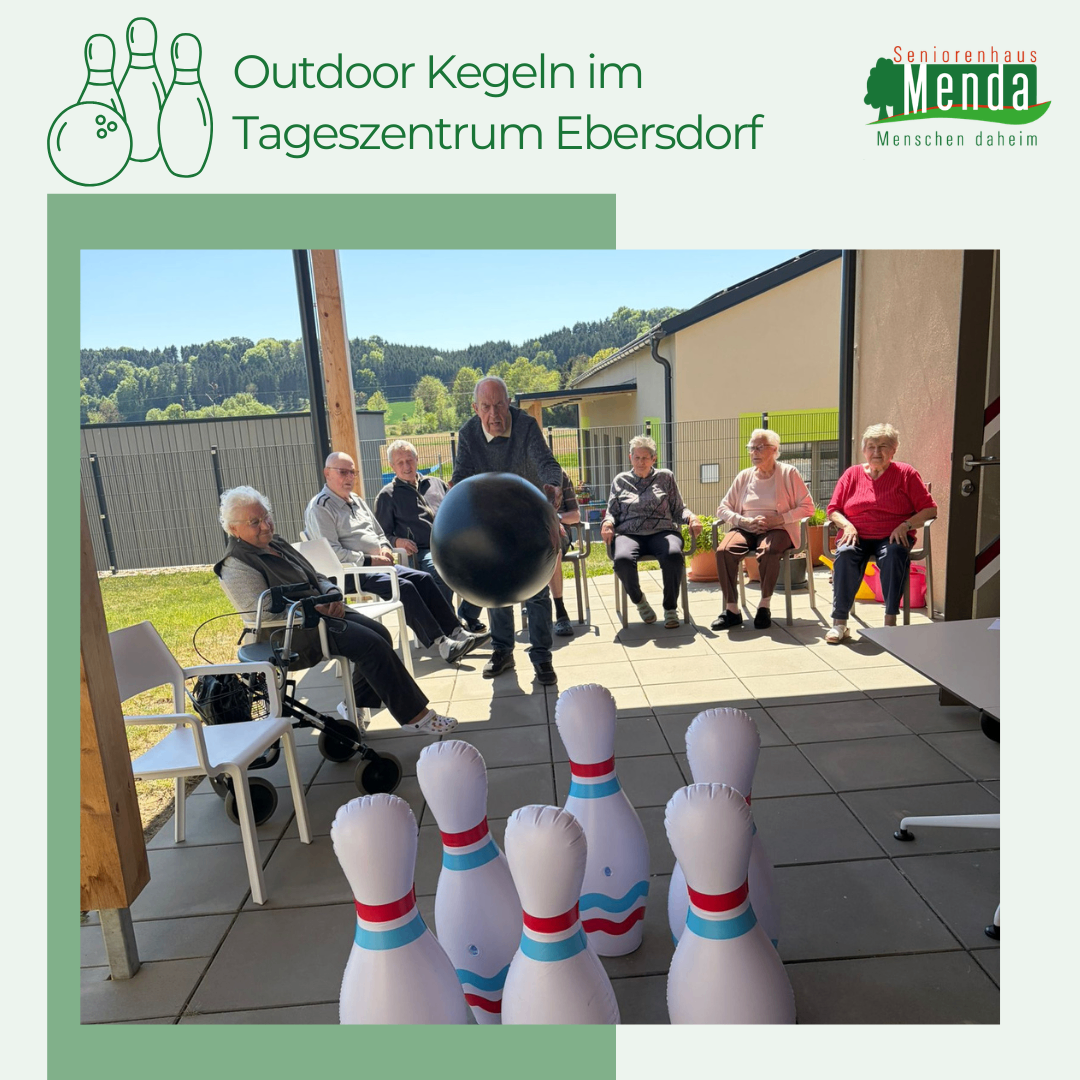 Senioren spielen Outdoor-Bowling im Tageszentrum Ebersdorf. Sie sitzen und ein Senior bereitet sich auf den Wurf vor. Vor ihnen stehen Bowlingkegel.