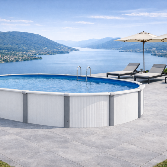 Ein ovaler Pool ist auf einer Terrasse mit Blick auf einen See und Berge installiert. In der Nähe befinden sich zwei Liegestühle und Sonnenschirme.