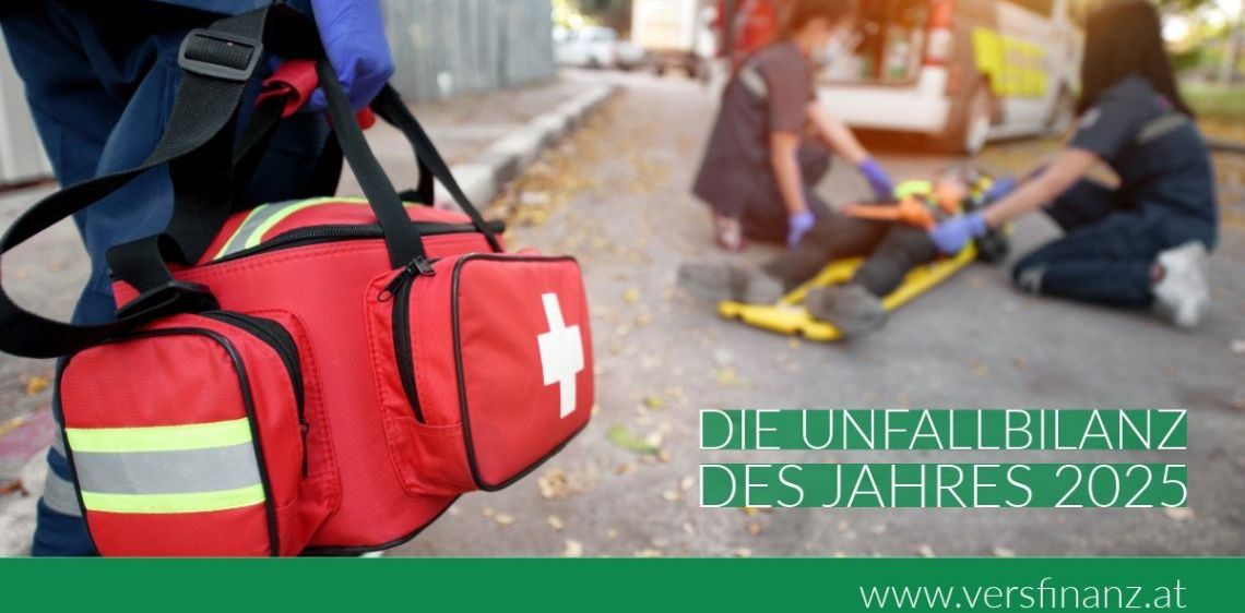Sanitäter kümmern sich um einen Patienten bei einem Unfall, im Hintergrund ein Krankenwagen. Das Bild zeigt eine rote Sanitätstasche.
