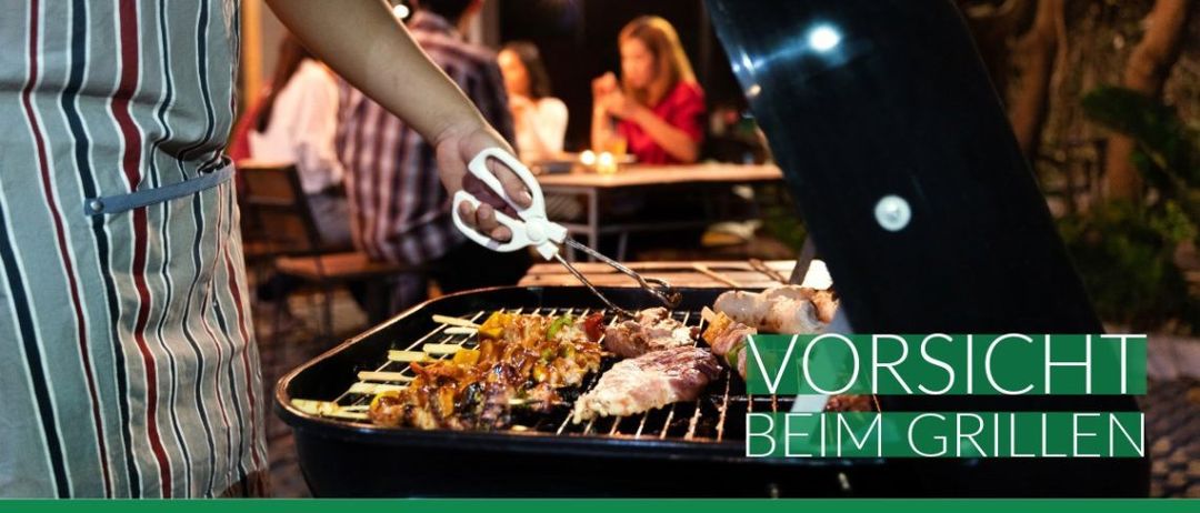 Eine Person kocht Fleisch auf einem Grill mit anderen in einem Restaurant bei Nacht.