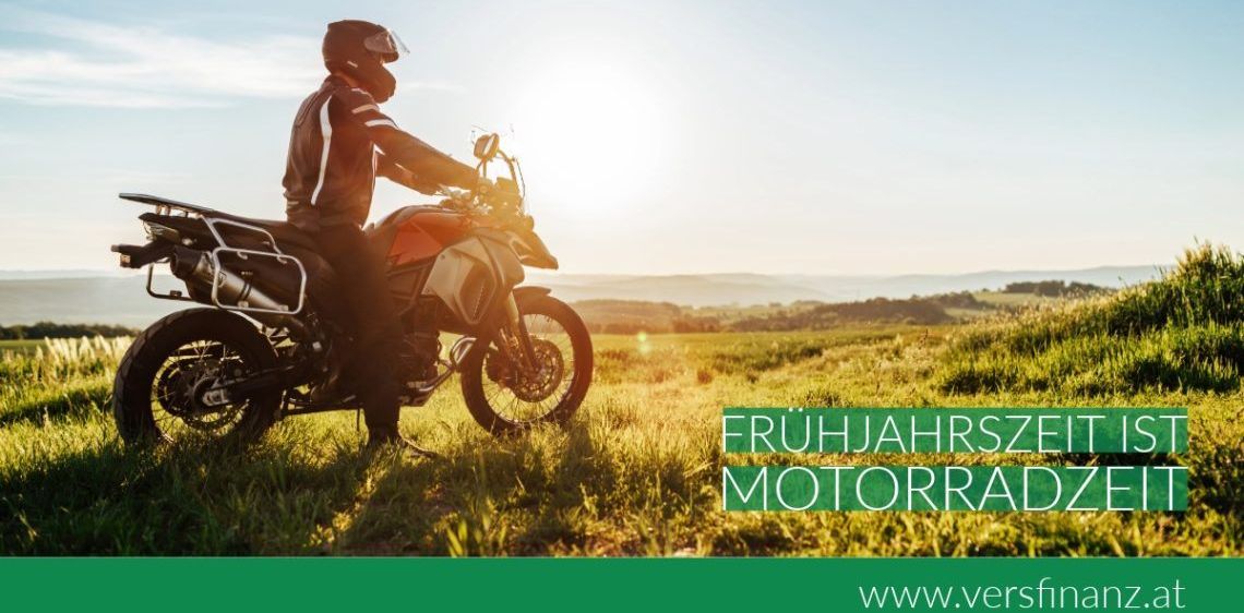 Ein Motorradfahrer steht auf einem Motorrad in einem Grasfeld mit Bergen im Hintergrund. Der Text lautet 'FRUHJAHRSZ MOTORRAI'. Unten befindet sich eine Website-URL.