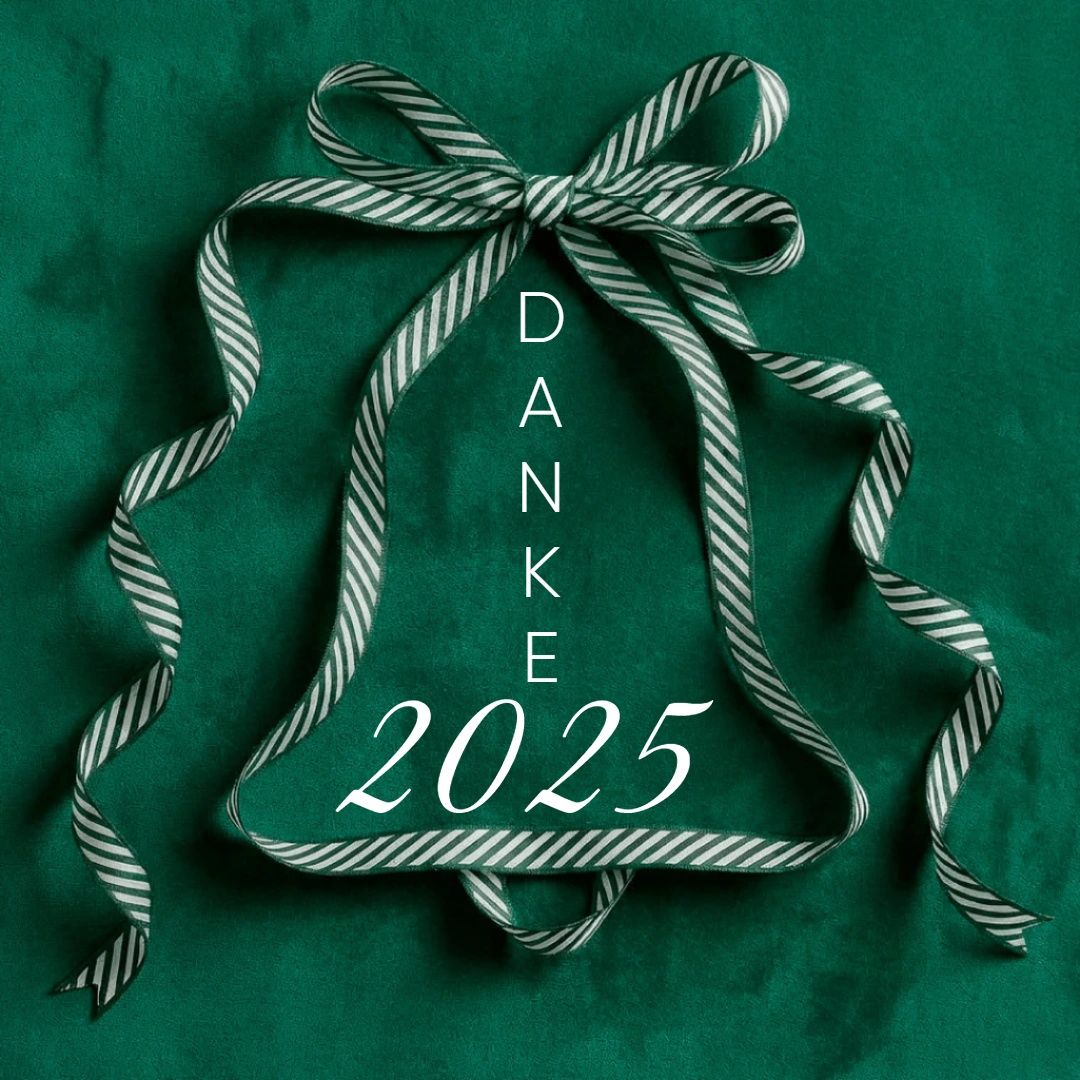 Ein grünes glockenförmiges Band mit den Worten Danke 2025. Das Band hat weiße und grüne Streifen. Es ist in einer Schleifenform gebunden. Das Band liegt auf einem grünen Hintergrund.