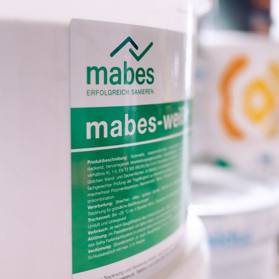 Nahaufnahme einer weißen Flasche mit dem Label 'mabes'. Grüner Text liest 'mabes-wei'. Enthält Produktbeschreibung, Anweisungen und Warnhinweise.